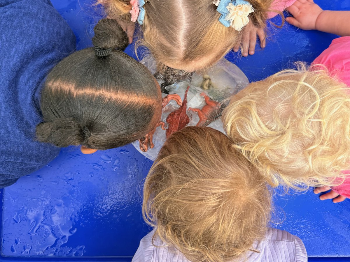Klein groepie kleuters wat saam by die watertafel ontdek en speel